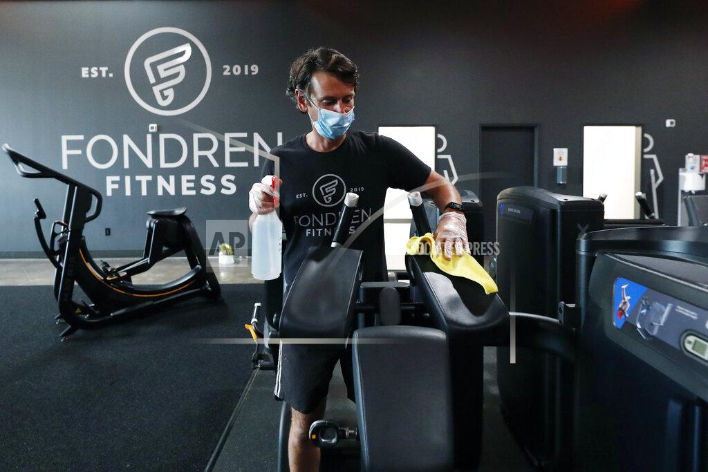 Rogelio V. Solis FILE - In this May 14, 2020 file photo, Terry Sullivan, general manager of Fondren Fitness, a Jackson, Miss., fitness center, sanitizes a workout machine. Fitness regimens shifted from the gym to the home in a big way during 2020. Interactive fitness bike maker Peloton was one of the biggest winners of the workout-from-home trend as gyms did not fare so well as people avoided crowded places. (AP Photo/Rogelio V. Solis)