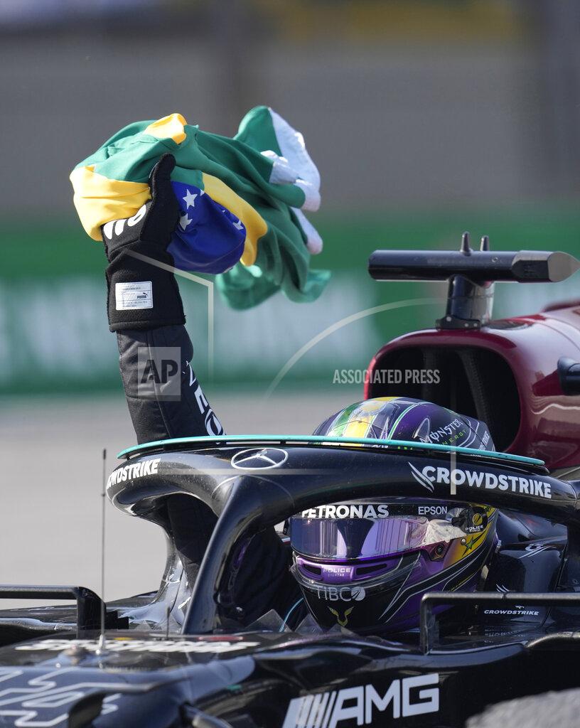Andre Penner Mercedes' Lewis Hamilton holds a Brazilian flag as he celebrates wining the Brazilian Formula One Grand Prix at the Interlagos race track in Sao Paulo, Brazil, Sunday, Nov. 14, 2021. (AP Photo/Andre Penner)