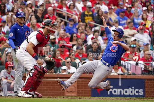 Chicago Cubs' Frank Schwindel, right, scores past St. Louis Cardinals catcher Andrew Knizner during the fifth inning of a baseball game Sunday, Oct. 3, 2021, in St. Louis. (AP Photo/Jeff Roberson)