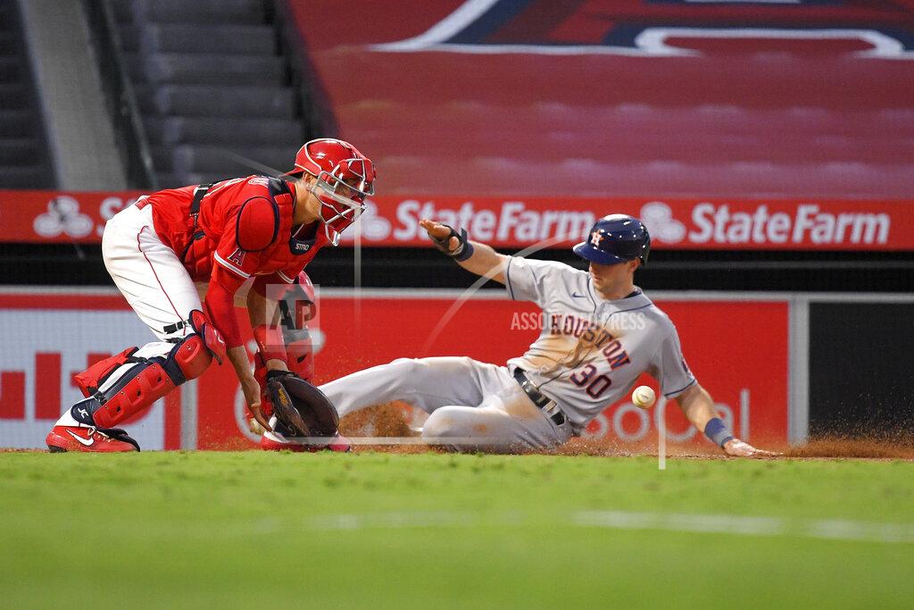 Mark J. Terrill Houston Astros' Kyle Tucker, right, scores on a sacrifice fly by George Springer as Los Angeles Angels catcher Jason Castro takes a late throw during the fourth inning of a baseball game Friday, July 31, 2020, in Anaheim, Calif. (AP Photo/Mark J. Terrill)