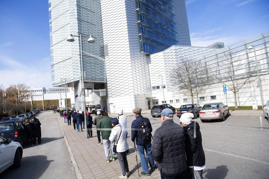 Fredrik Sandberg People queue to receive a COVID-19 vaccine, outside the Stockholmsmassan exhibition center turned mass vaccination center, in Stockholm, Sweden, Thursday April 8, 2021. (Fredrik Sandberg/TT News Agency via AP)