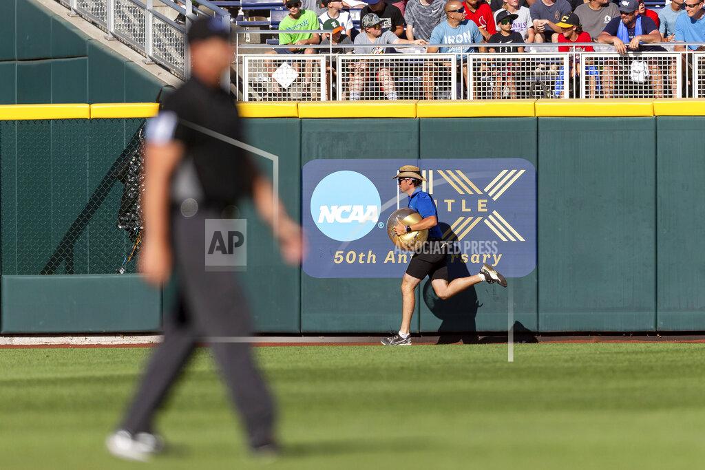 John Peterson Grounds crew member removes a beach ball from left field in the game between Arkansas and Mississippi in the third inning during an NCAA College World Series baseball game Wednesday, June 22, 2022, in Omaha, Neb. (AP Photo/John Peterson)
