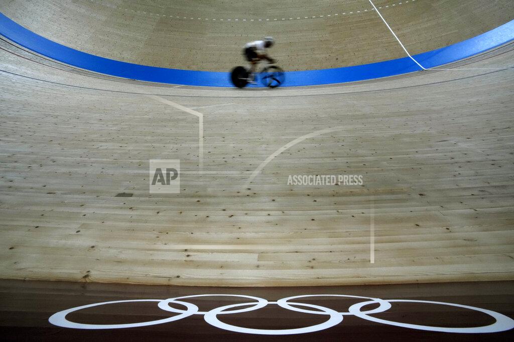 Christophe Ena A rider rounds the track past Olympic Rings during a training session inside the Izu velodrome at the 2020 Summer Olympics, Sunday, Aug. 1, 2021, in Izu, Japan. (AP Photo/Christophe Ena)