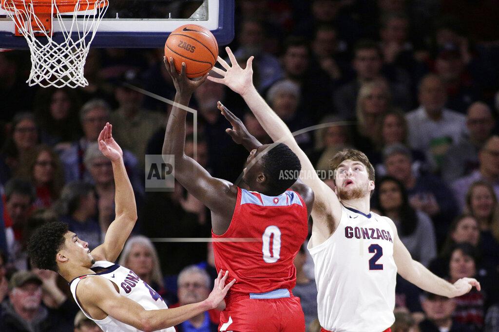 Young Kwak Loyola Marymount guard Eli Scott, center, shoots between Gonzaga guard Ryan Woolridge, left, and forward Drew Timme during the first half of an NCAA college basketball game in Spokane, Wash., Thursday, Feb. 6, 2020. (AP Photo/Young Kwak)