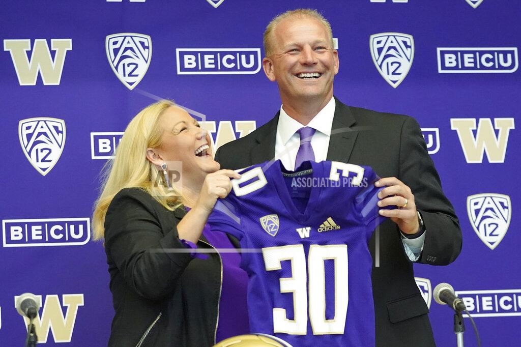 Ted S. Warren Washington athletic director Jen Cohen, left, poses for a photo with Kalen DeBoer, right, Tuesday, Nov. 30, 2021, during a news conference in Seattle to introduce DeBoer as the new head NCAA college football coach at the University of Washington. DeBoer has spent the past two seasons as head football coach at Fresno State. (AP Photo/Ted S. Warren)