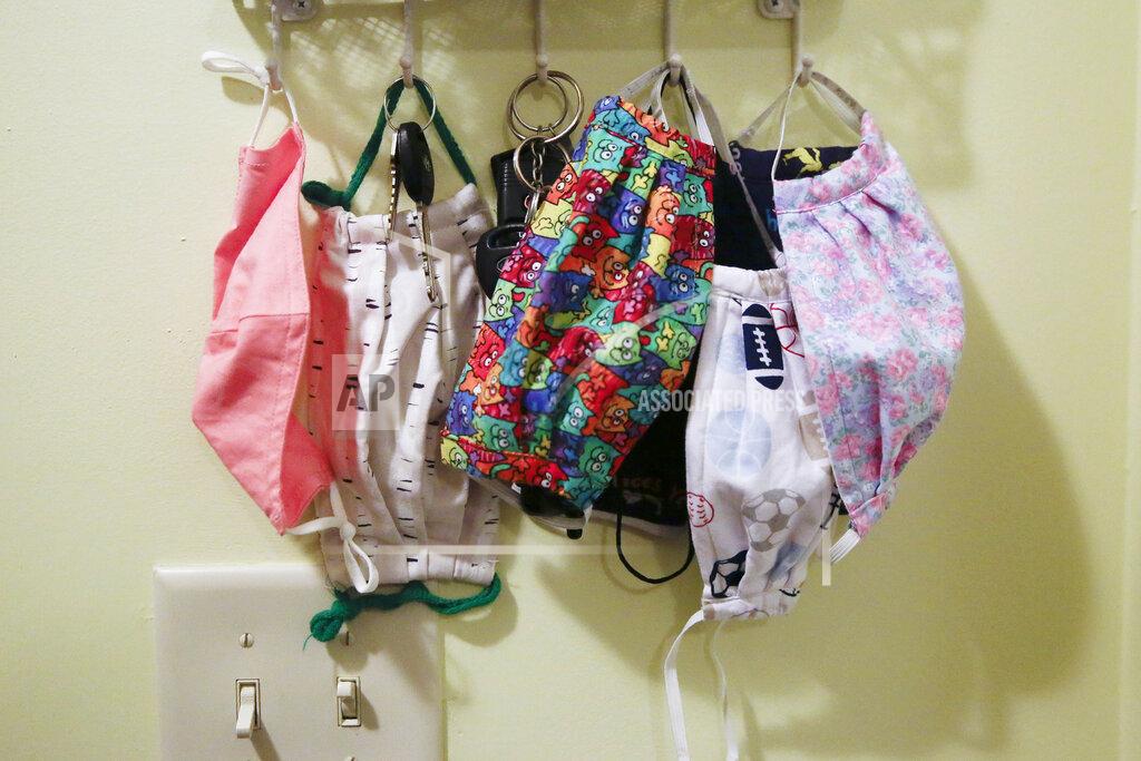Brynn Anderson Face coverings hang on hooks along with keys by the front door of the Adamus family on Monday, Aug. 3, 2020, in Dallas, Ga. The Adamus children are among tens of thousands of students in Georgia and across the nation who were set to resume in-person school Monday for the first time since March. (AP Photo/Brynn Anderson)