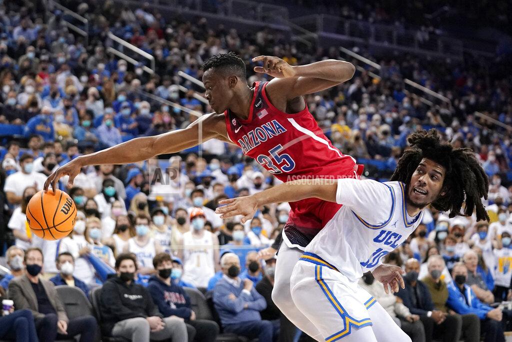 Mark J. Terrill Arizona center Christian Koloko, left, reaches for a loose ball along with UCLA guard Tyger Campbell during the first half of an NCAA college basketball game Tuesday, Jan. 25, 2022, in Los Angeles. (AP Photo/Mark J. Terrill)