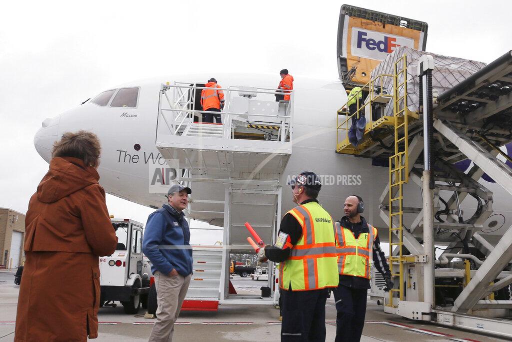 Charles Krupa Gov. Chris Sununu, center, talks with the ground crew as over 110,000 pounds of personal protective equipment (PPE) from Shanghai, China, delivered to protect medical workers and first responders fighting the COVID-19 coronavirus outbreak, is unloaded from a cargo plane at Manchester-Boston Regional Airport in Manchester, N.H., Thursday, April 30, 2020. (AP Photo/Charles Krupa)