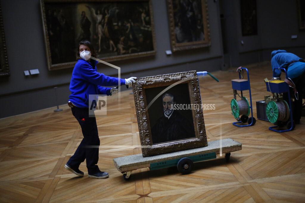 Thibault Camus A worker transports the painting called 'Portrait of Antonio de Covarrubias y Leiva' by Spanish painter El Greco, in the Louvre museum, in Paris, Tuesday, Feb. 9, 2021. Though empty corridors and vacant galleries are a grim sight for frustrated art-lovers, they are a golden opportunity to do works of renovation, refurbishment and re-ordering that were simply not possible with the around 10 million visitors per year. (AP Photo/Thibault Camus)