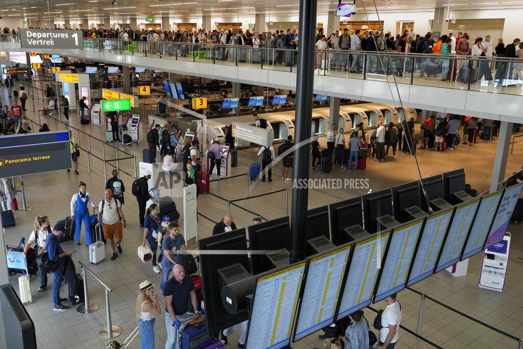 Peter Dejong FILE - Travelers wait in long lines to check in and board flights at Amsterdam's Schiphol Airport, Netherlands, Tuesday, June 21, 2022. (AP Photo/Peter Dejong, File)