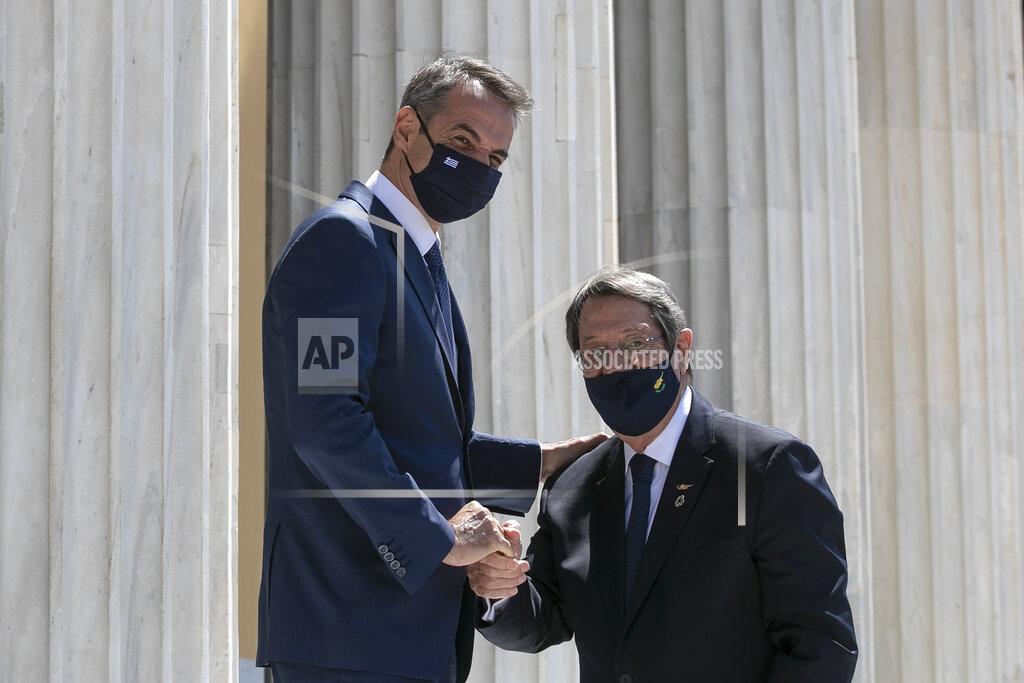 Yorgos Karahalis Greece's Prime Minister Kyriakos Mitsotakis, left, shakes hands with Cyrpiot President Nikos Anastasiades ahead of a meeting in Athens, on Wednesday, July 28, 2021. Greece hosts a one-day trilateral meeting of Greece, Jordan and Cyprus. (AP Photo/Yorgos Karahalis)
