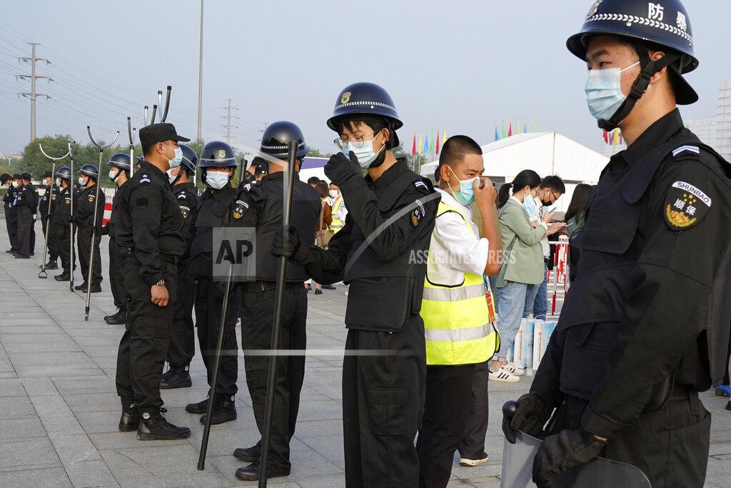 Ng Han Guan Security guards wearing masks and armed with restrainers stand guard at the entrance to the Auto China 2020 show in Beijing, China on Saturday, Sept. 26, 2020. The auto show, the first major in-person sales event for any industry since the coronavirus pandemic began, opens Saturday in a sign the ruling Communist Party is confident China has contained the disease. Still, automakers face intensive anti-virus controls including quarantines for visitors from abroad and curbs on crowd sizes at an event that usually is packed shoulder-to-shoulder with spectators. (AP Photo/Ng Han Guan)