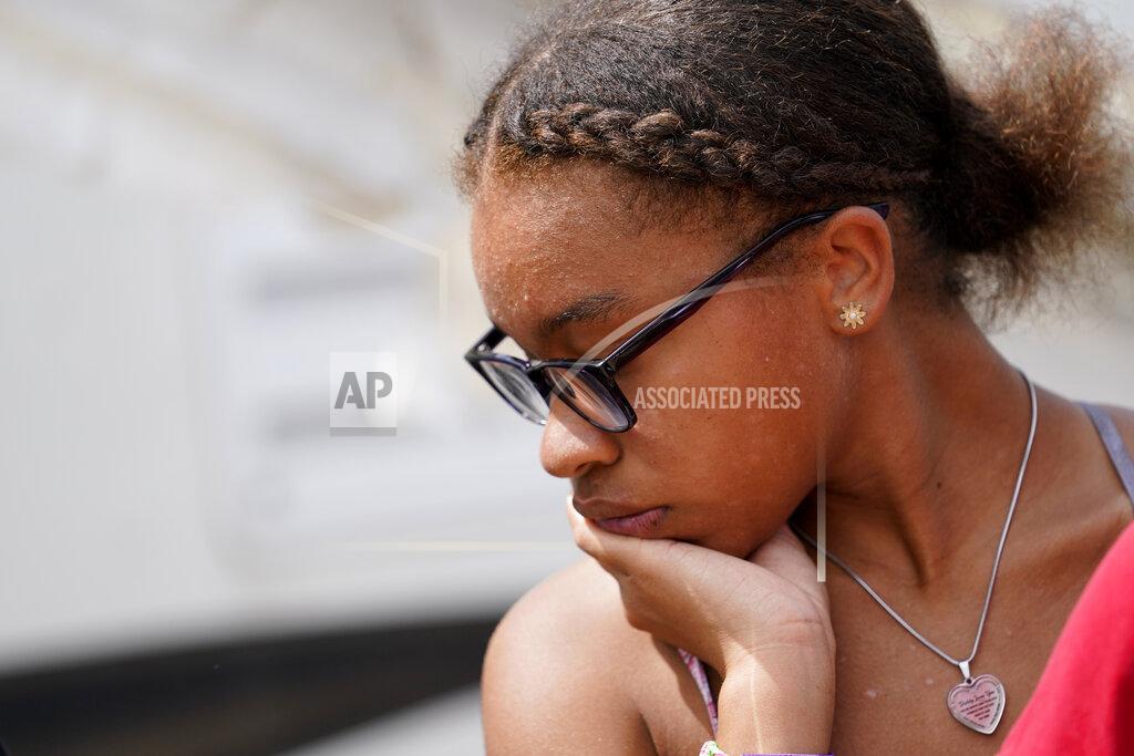 Gerald Herbert Amiah Winbush, 17, reacts as she looks at the damage to her family's auto detailing business in Lake Charles, La., in the aftermath of Hurricane Laura, Sunday, Aug. 30, 2020. (AP Photo/Gerald Herbert)