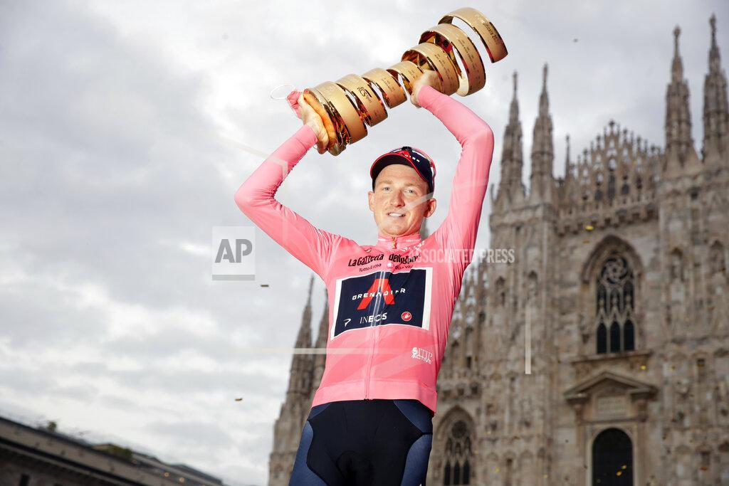Luca Bruno Britain's Tao Geoghegan Hart, framed by the gothic cathedral, holds up the trophy after winning the Giro d'Italia cycling race, in Milan, Italy, Sunday, Oct. 25, 2020. (AP Photo/Luca Bruno)