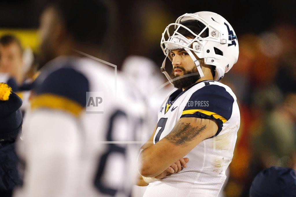 Charlie Neibergall FILE - In this Oct. 13, 2018 file photo, West Virginia quarterback Will Grier watches from the bench during the second half of an NCAA college football game against Iowa State in Ames, Iowa. The No. 12 Mountaineers and No. 15 Texas Longhorns play Saturday in a game both need to win to keep a share of the conference lead with an eye toward the conference title game in December. (AP Photo/Charlie Neibergall, File)