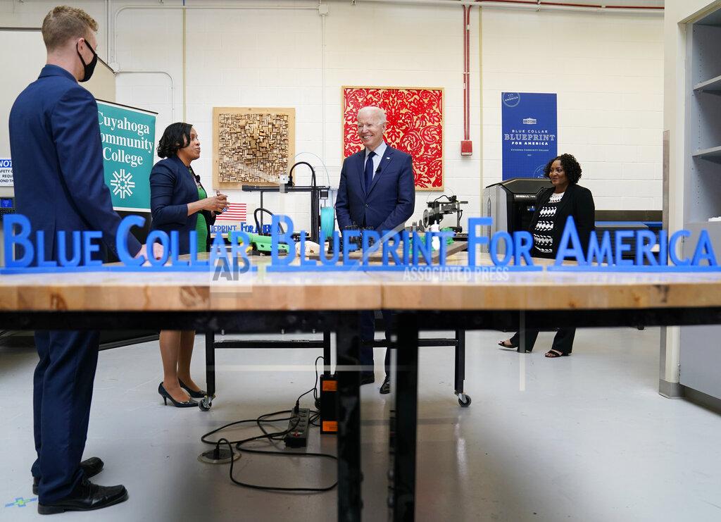 Evan Vucci President Joe Biden smiles during a tour of the Cuyahoga Community College Manufacturing Technology Center, Thursday, May 27, 2021, in Cleveland. (AP Photo/Evan Vucci)