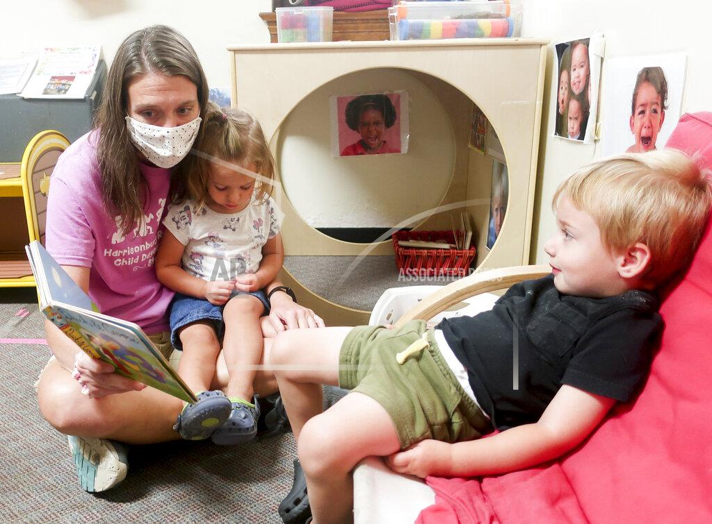 Ian Munro In this Sept. 13, 2021, photo, Carla Hart, a long-time child care worker at the Harrisonburg-Rockingham Child Day Care Center in Harrisonburg, Va., reads a story to two kids in her class who just got up from a nap. (Ian Munro/Daily News-Record via AP)