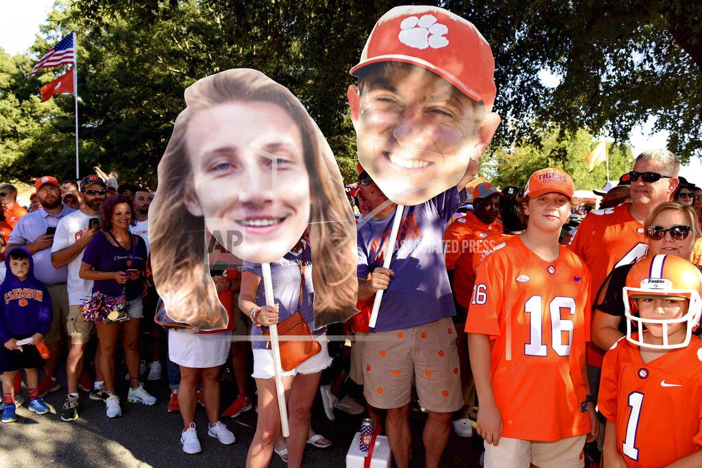 Richard Shiro Clemson fans hold large images of Trevor Lawrence, left, and coach Dabo Swinney during the Tiger Walk before the team's NCAA college football game against Georgia Tech on Thursday, Aug. 29, 2019, in Clemson, S.C. (AP Photo/Richard Shiro)