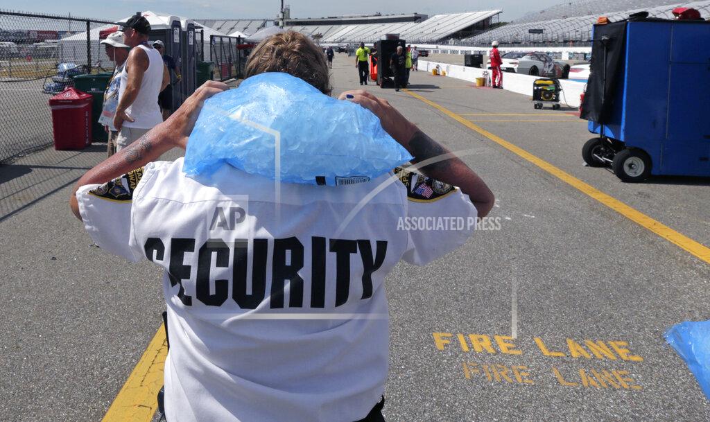Charles Krupa Track security officer Patty Patterson carries a bag of ice on her shoulders as she walks back to her post during a NASCAR Cup Series auto race practice at New Hampshire Motor Speedway in Loudon, N.H., Saturday, July 20, 2019. Temperatures were forecasted to reach nearly 100 degrees at the track. (AP Photo/Charles Krupa)