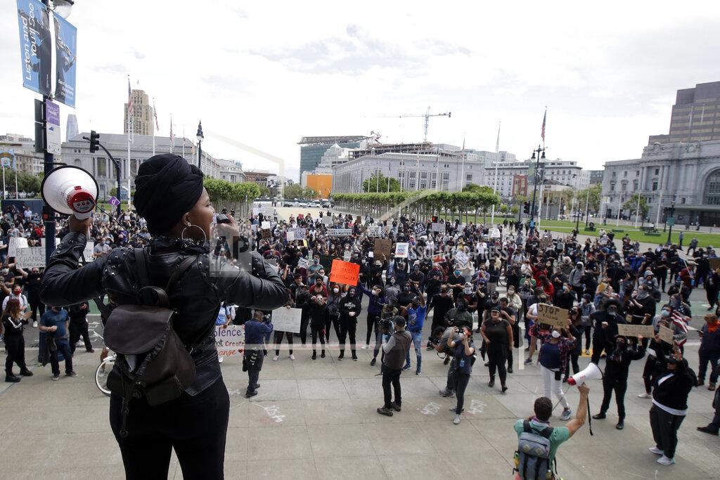 Jeff Chiu Raiah Sinn, foreground, speaks at a protest over the Memorial Day death of George Floyd, a handcuffed black man in police custody in Minneapolis, in San Francisco, Saturday, May 30, 2020. (AP Photo/Jeff Chiu)