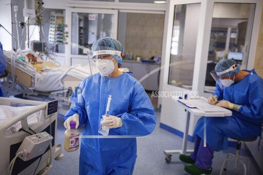 A health worker carries medication inside the Intensive Care Unit at the hospital in Bochnia, Poland, Monday March 26, 2021. Polish hospitals struggled over the Easter weekend with a massive number of people infected with COVID-19 following a huge surge in infections across Central and Eastern Europe in recent weeks. Tougher new pandemic restrictions were ordered in Poland for a two-week period surrounding Easter in order to slow down the infection rate. (AP Photo/Omar Marques)