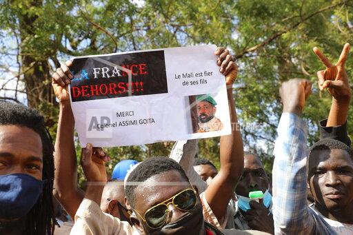 Thousands join a government-sponsored rally in Mali's capital Bamako Friday Jan. 14, 2021 to protest new regional economic sanctions and growing pressure from former coloniser France, after Mali's military ruler pushed back promised elections by four years. Sign reads: "France Out" , "Mali is proud of its sons" and "Thank you Colonel Assimi Goita." (AP Photo/Harandane Dicko)