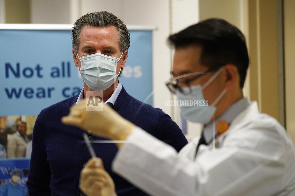 Jae Hong FILE - In this Dec. 14, 2020, file photo, California Gov. Gavin Newsom watches as a Pfizer COVID-19 vaccine is prepared by Director of Inpatient Pharmacy David Cheng at Kaiser Permanente Los Angeles Medical Center in Los Angeles. Newsom and his Democratic allies launched a campaign committee Monday, March 15, 2021, to stop a proposed recall election that could oust him from office. (AP Photo/Jae C. Hong, File)