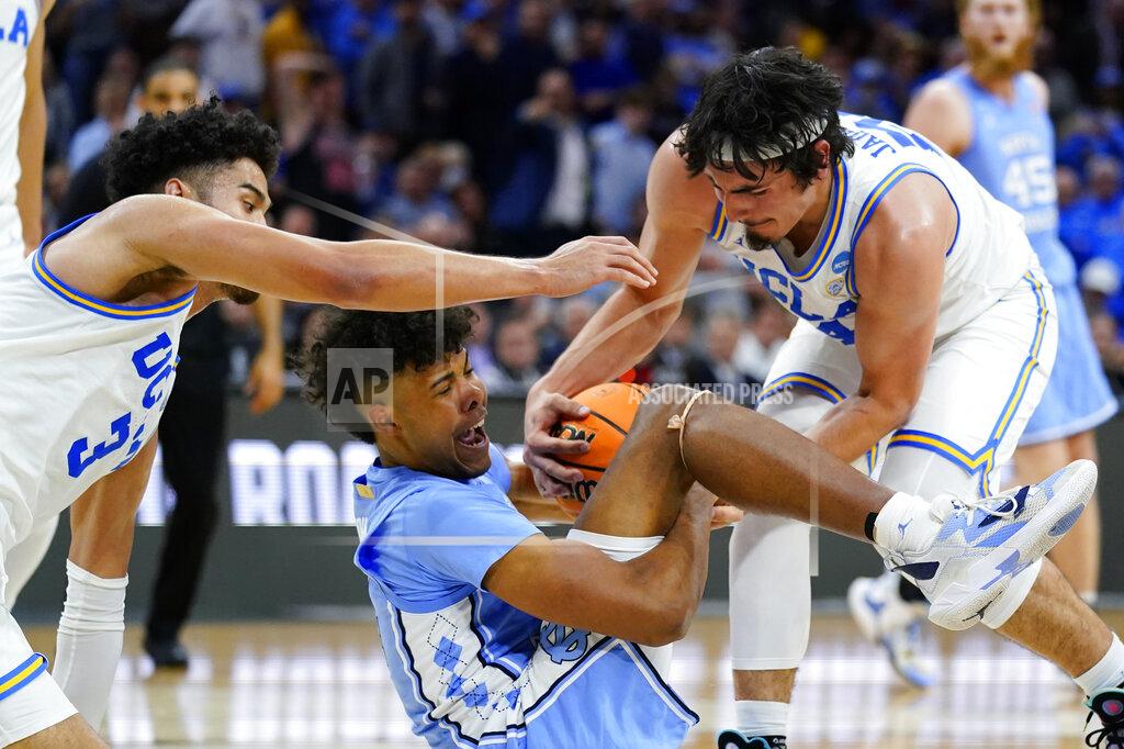 Matt Rourke North Carolina's Puff Johnson, center, battles for a loose ball with UCLA's Johnny Juzang, left, and Jaime Jaquez Jr. during the second half of a college basketball game in the Sweet 16 round of the NCAA tournament, Friday, March 25, 2022, in Philadelphia. (AP Photo/Matt Rourke)