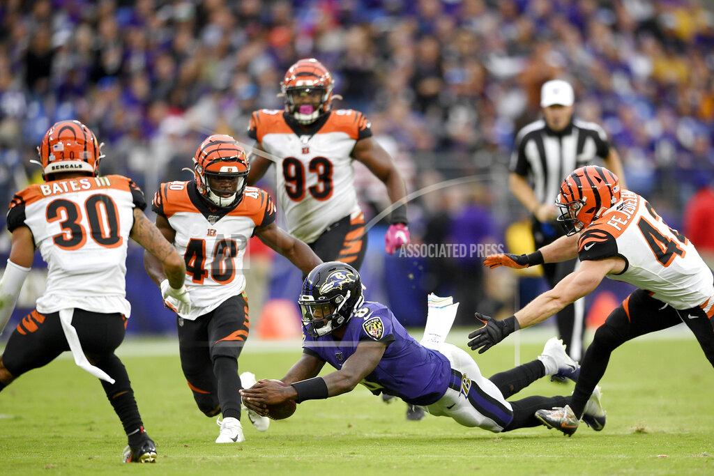 Nick Wass Baltimore Ravens quarterback Lamar Jackson, bottom, dives forward during a run as a host of Cincinnati Bengals defenders try to get to him during the second half of a NFL football game Sunday, Oct. 13, 2019, in Baltimore. (AP Photo/Nick Wass)