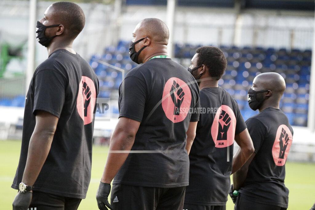 John Raoux Members of all the MLS soccer teams march around the stadium before a match Wednesday, July 8, 2020, in Kissimmee, Fla., while wearing shirts and masks with messages about race. (AP Photo/John Raoux)