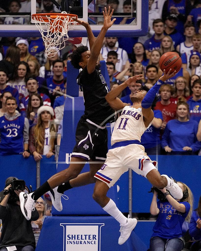 Charlie Riedel Kansas' Remy Martin (11) shoots under pressure from Stephen F. Austin's Calvin Solomon during the second half of an NCAA college basketball game Saturday, Dec. 18, 2021, in Lawrence, Kan. (AP Photo/Charlie Riedel)