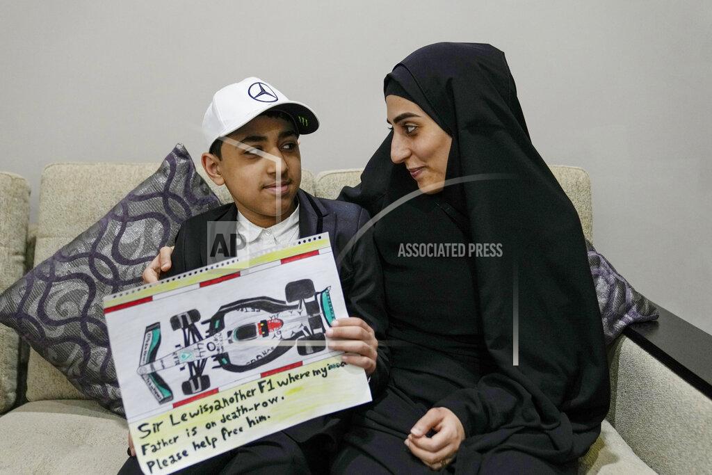 Uncredited Ahmed, 12 years old, son of Mohammed Ramadhan, a former member of Bahrain's security forces who is facing the death penalty in Bahrain, holds a drawing he made of F1 driver Lewis Hamilton's Formula One car, as he poses for a photograph with his mother Zainab Ebrahim in Manama, Bahrain, Thursday, March 17, 2022. Ahead of Sunday's season-opening F1 race in Bahrain, Ahmed proudly held up the drawing of Hamilton's famed No. 44 Mercedes car along with his own words of hope: "Sir Lewis, another F1 where my innocent father is on death row. Please help free him." (AP Photo)