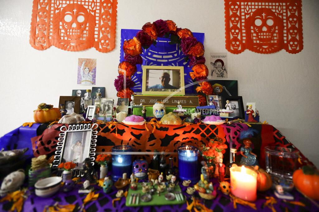 A portrait of Dr. Jose Luis Linares who died from symptoms related to COVID-19, placed on a Day of the Dead altar made by his wife Rosario Martinez at their home in Mexico City, Sunday, Nov. 1, 2020. He is one of more than 1,700 Mexican health workers officially known to have died of COVID-19 who are behind honored with three days of national mourning on these Days of the Dead. (AP Photo/Eduardo Verdugo)
