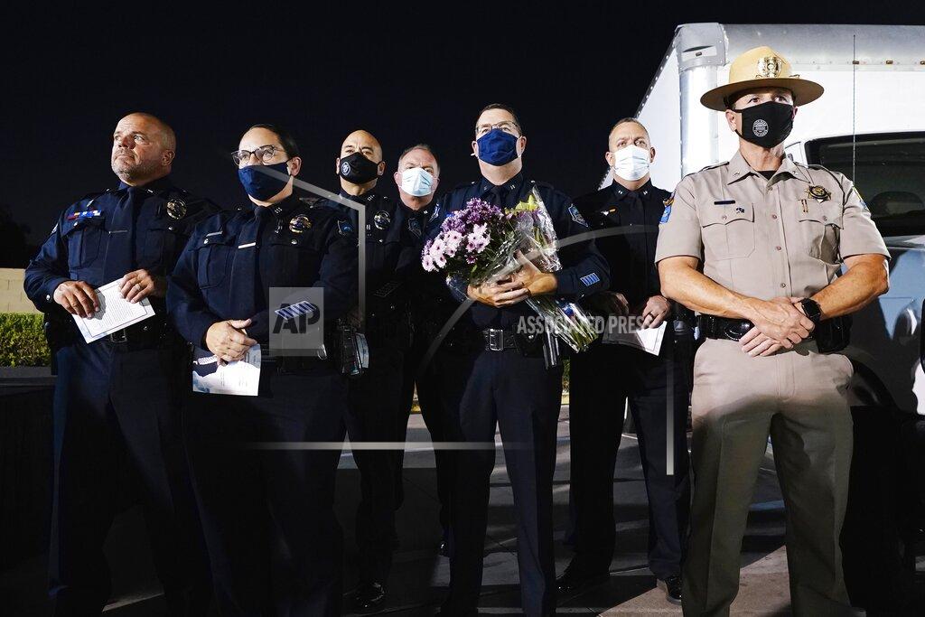 Ross D. Franklin Local and state law enforcement officers attend a memorial service on the 20th anniversary of the murder of Balbir Singh Sodhi Wednesday, Sept. 15, 2021, in Mesa, Ariz. Sikh businessman Balbir Singh Sodhi was helping plant a flower bed at his Arizona gas station when he was shot dead by a man seeking to avenge 9/11. Mistaken for an Arab Muslim because of his turban and beard, Sodhi was the first person to die in a wave of bias crimes unleashed by the attacks. (AP Photo/Ross D. Franklin)