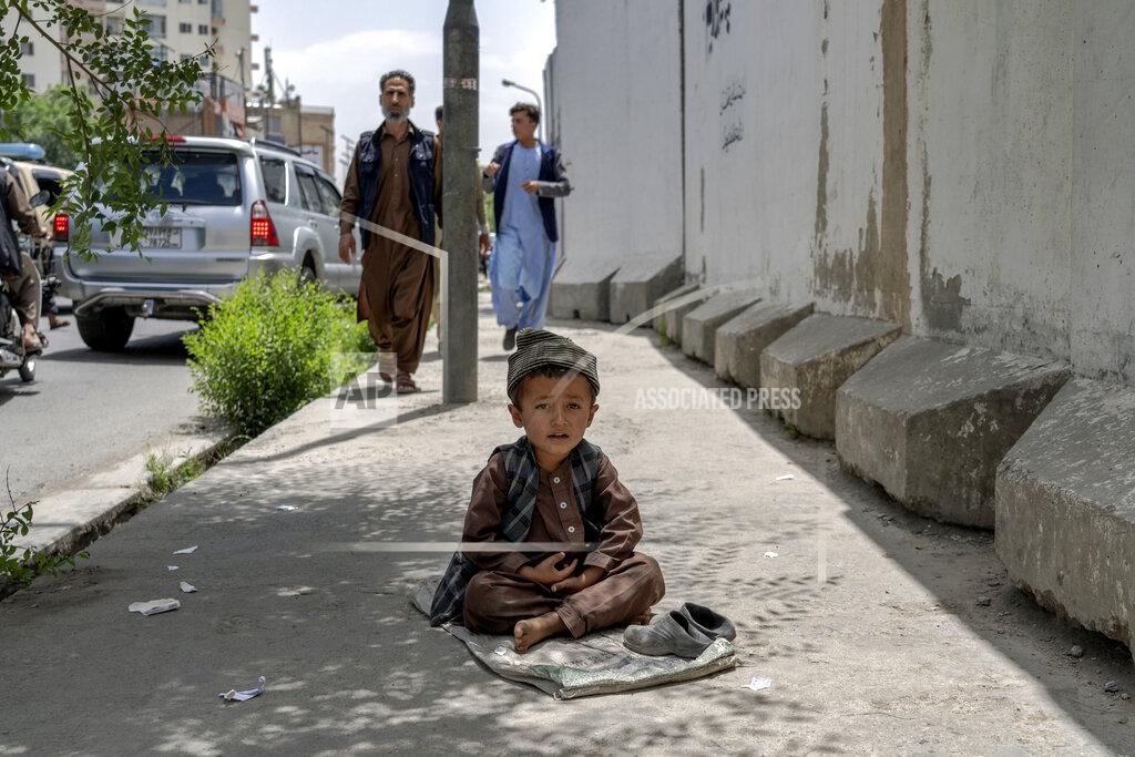 Ebrahim Noroozi A child begs on a side walk in Kabul, Afghanistan, Sunday, May 22, 2022. Some 1.1 million Afghan children under the age of five will face malnutrition by the end of the year. , as hospitals wards are already packed with sick children . (AP Photo/Ebrahim Noroozi)