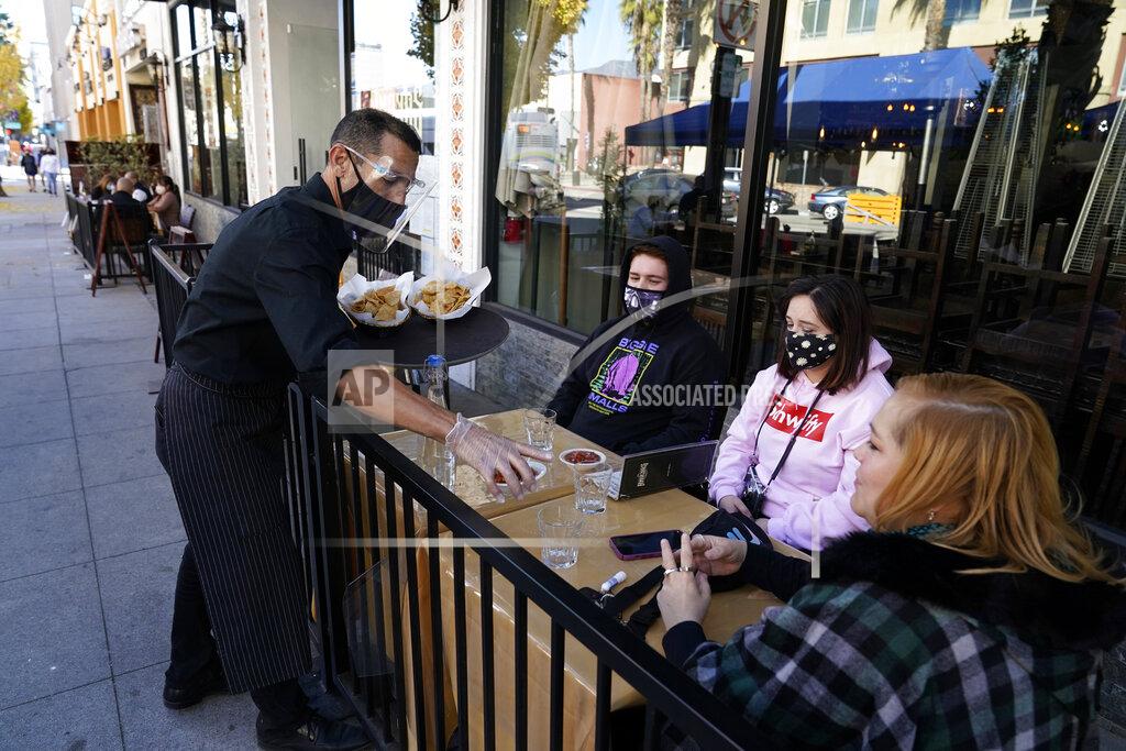 Marcio Jose Sanchez Customers are served lunch at an outdoor seating space Tuesday, Dec. 1, 2020, in Pasadena, Calif. Pasadena has become an island in the center of the nation's most populous county, where a surge of COVID-19 cases last week led to a three-week end to outdoor dining and California's first stay-home order since the pandemic began to spread across the state in March. (AP Photo/Marcio Jose Sanchez)