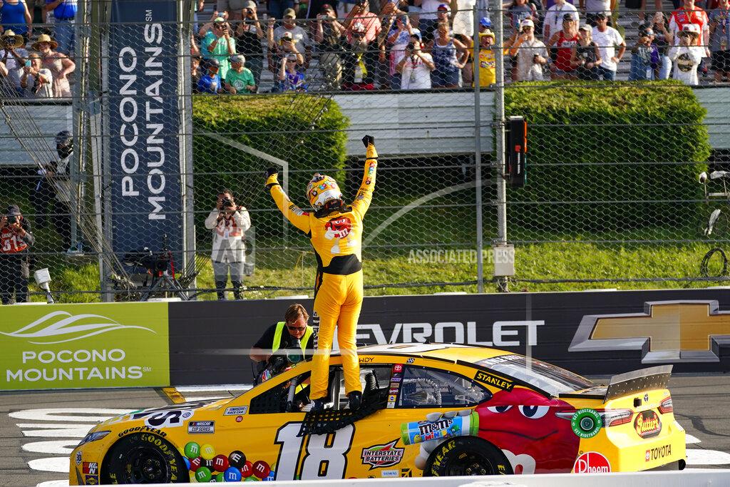 Matt Slocum Fans cheer as Kyle Busch stands on the window opening of his race car and celebrates winning a NASCAR Cup Series auto race at Pocono Raceway, Sunday, June 27, 2021, in Long Pond, Pa. (AP Photo/Matt Slocum)