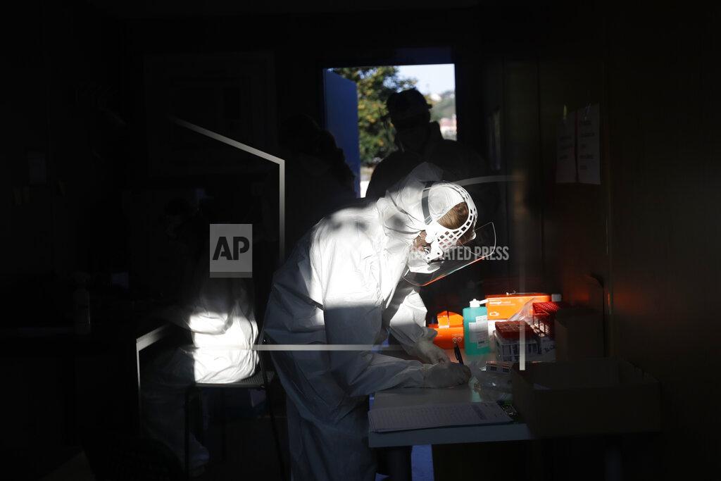 A healthcare worker at a sampling station for COVID-19 in Prague, Czech Republic, Monday, Sept. 21, 2020. The country coped well with the first wave of the coronavirus infections in the spring but has been facing a record surge of the new confirmed cases last week. (AP Photo/Petr David Josek)