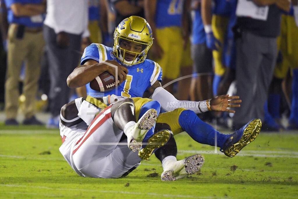 Mark J. Terrill UCLA quarterback Dorian Thompson-Robinson, top, is sacked by Oklahoma linebacker Brian Asamoah during the second half of an NCAA college football game Saturday, Sept. 14, 2019, in Pasadena, Calif. (AP Photo/Mark J. Terrill)