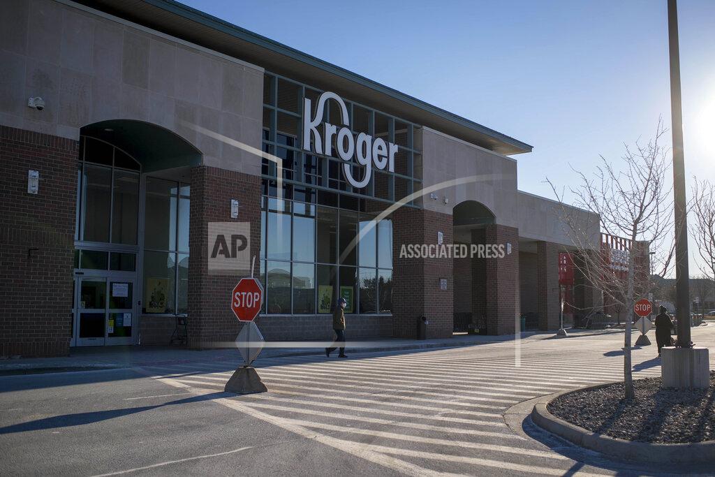Nic Antaya A person walks across the street outside of the Kroger in Novi, Mich on Jan. 23, 2021. A $1 billion winning Mega Millions ticket was sold at the store for the drawing held on Friday, Jan. 22. (Nic Antaya/Detroit News via AP)