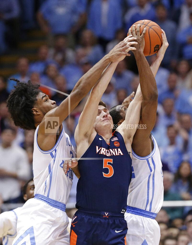 Gerry Broome North Carolina's Coby White and Kenny Williams, right, reach for the ball with Virginia's Kyle Guy (5) during the second half of an NCAA college basketball game in Chapel Hill, N.C., Monday, Feb. 11, 2019. Virginia won 69-61. (AP Photo/Gerry Broome)