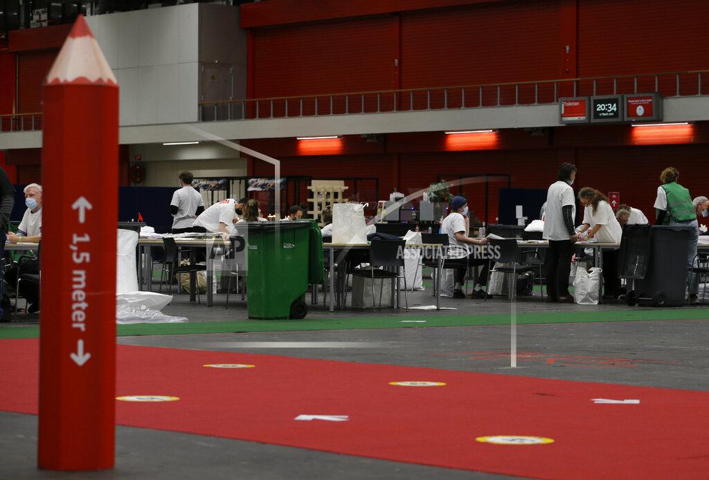 Peter Dejong A red voting pencil with a social distancing message sits in a hall of a congress center where votes are being counted in general election in Amsterdam, Netherlands, Wednesday, March 17, 2021. The election was spread over three days to allow people to vote safely during the coronavirus pandemic, an exit poll published immediately after voting ended in the Dutch general election suggested that the conservative party of caretaker Prime Minister Mark Rutte has won the most seats, putting him first in line to form a new ruling coalition. (AP Photo/Peter Dejong)