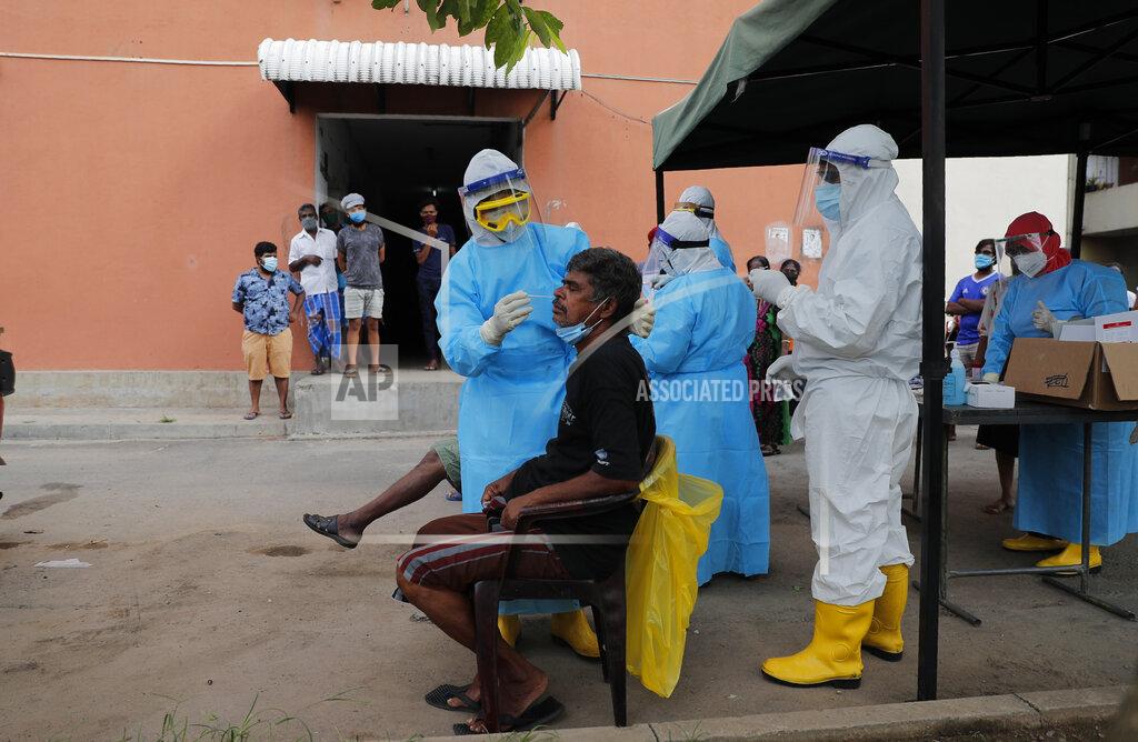 Eranga Jayawardena A Sri Lankan health official takes swab samples from a man to test for COVID-19 in Colombo, Sri Lanka, Monday, Nov. 23, 2020. (AP Photo/Eranga Jayawardena)