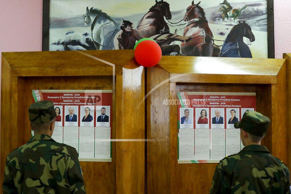 Sergei Grits Belarus soldiers look at posters with portraits of presidential candidates at a polling station during a early voting ahead of Sunday's election in Minsk, Belarus, Tuesday, Aug. 4, 2020. Belarus's authoritarian leader is vowing to maintain a close alliance with Russia despite the latest tensions as he seeks a sixth term in office amid a surge of opposition protests. President Alexander Lukashenko's comments in a state-of-the-nation address ahead of Sunday's election contrast with his diatribes against Russia last week. (AP Photo/Sergei Grits)
