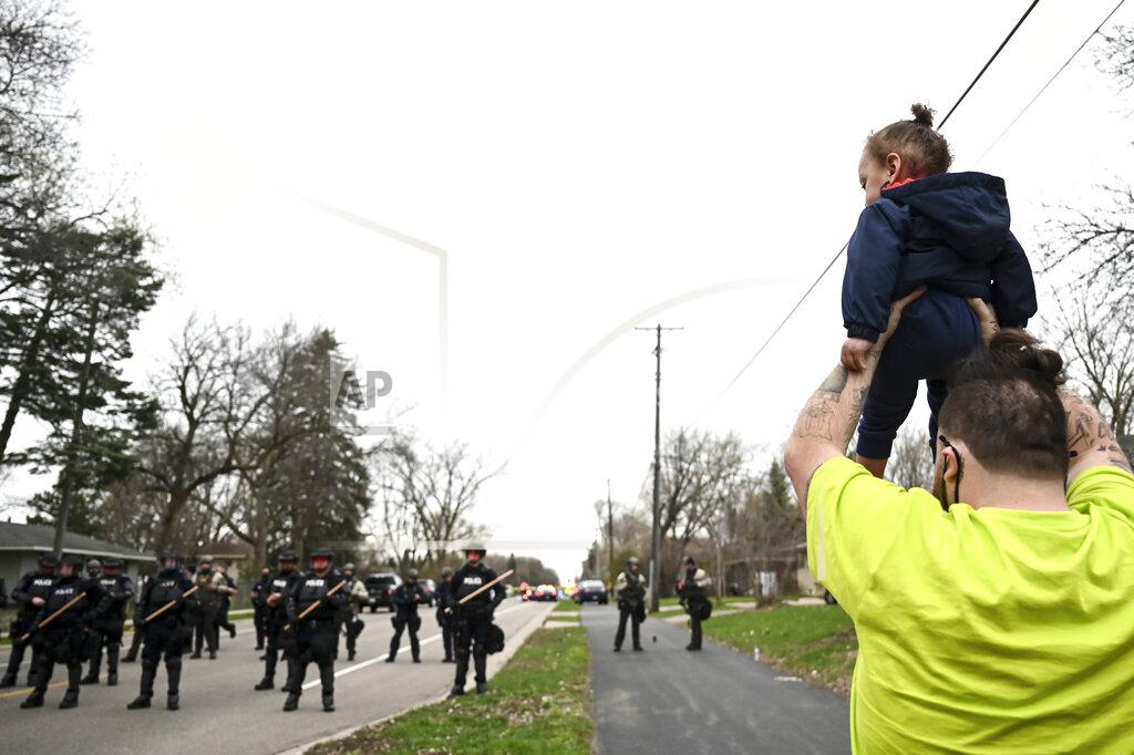 Aaron Lavinsky Damik Wright, brother of Daunte Wright, who the family said was shot and killed earlier Sunday by police, holds Daunte's son Daunte Jr., over his head to look at police officers assembling with riot gear at 63rd Avenue North and Lee Avenue North, Sunday, April 11, 2021, in Brooklyn Center, Minn. (Aaron Lavinsky/Star Tribune via AP)