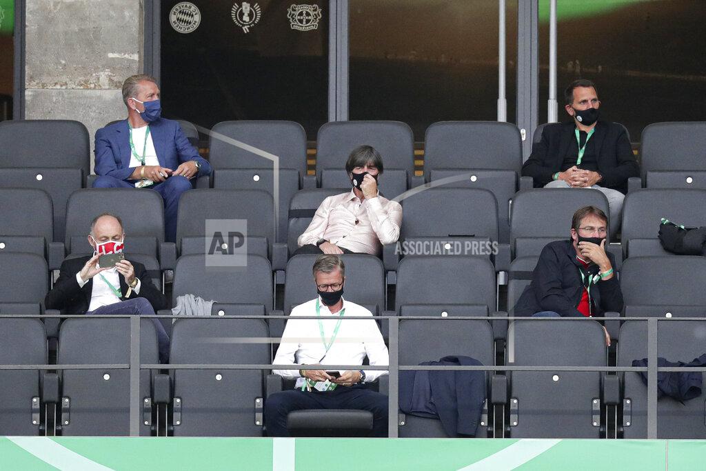 Michael Sohn Joachim Loew, head coach of the German national team, center, touches his mask during the German soccer cup (DFB Pokal) final match between Bayer 04 Leverkusen and FC Bayern Munich in Berlin, Germany, Saturday, July 4, 2020. (AP Photo/Michael Sohn)