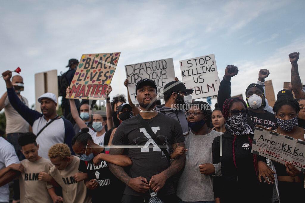 Brooke Herbert Trail Blazers point guard Damian Lillard marches alongside protesters towards downtown Portland on the Morrison Bridge, on June 4, 2020. Thousands of protesters in the liberal and predominantly white city of Portland, Ore. have taken to the streets peacefully every day for more than five weeks to decry police brutality, but recent violence by smaller groups is creating a deep schism in the protest movement and prompting allegations that white protesters are co-opting the moment. (Brooke Herbert/The Oregonian via AP)