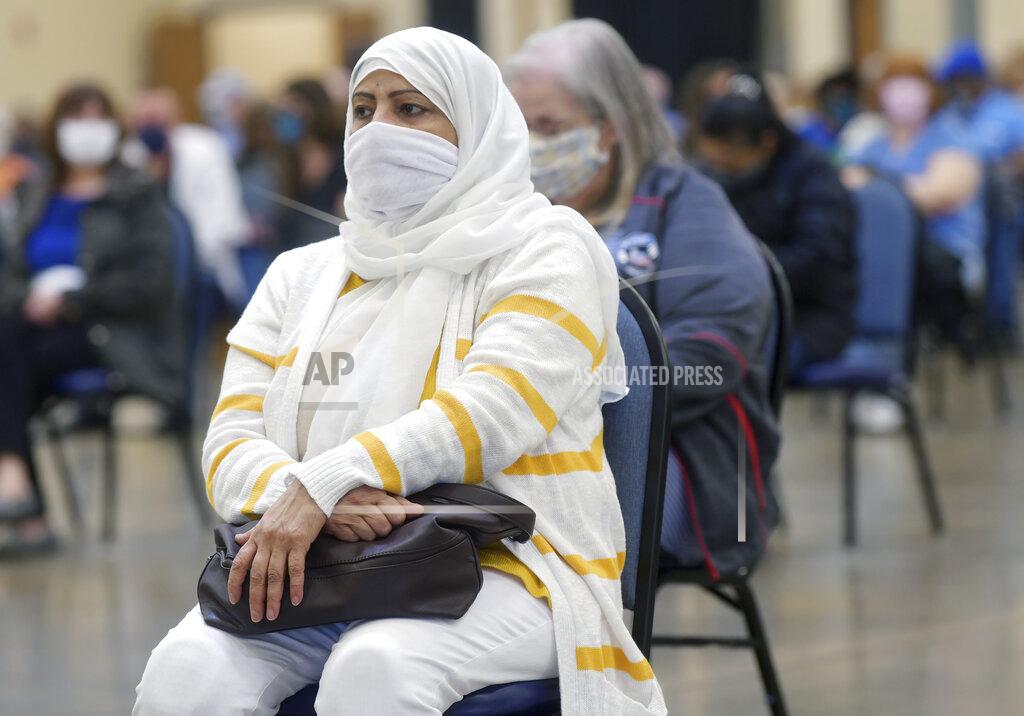 Uncredited Shagufta Bokharee, of Monroeville, and others wait the required amount of time after receiving the COVID vaccine, Tuesday, March 9, 2021, at the Monroeville Convention Center in Monroeville. Allegheny Health Network (AHN) and the Monroeville Chamber of Commerce partnered to provide the COVID-19 vaccinations to 5,100 area residents. Vaccine recipients will return to the Monroeville Convention Center on Tuesday, March 30th, to receive a second dose of the vaccine. (Pittsburgh Post-Gazette via AP)
