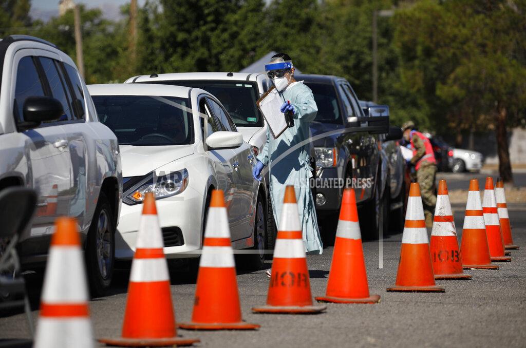 A healthcare worker directs patients in their cars at a drive-thru coronavirus testing site run by the University of Nevada Las Vegas School of Medicine and the Nevada National Guard, Friday, July 10, 2020, in Las Vegas. (AP Photo/John Locher)