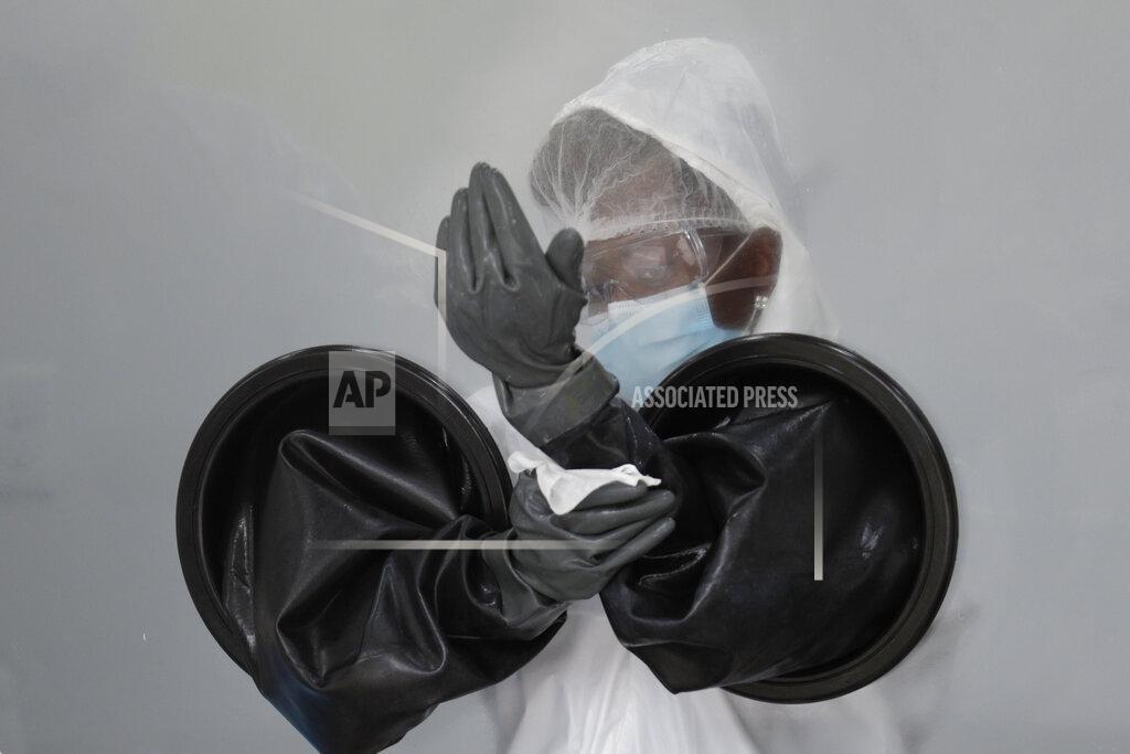 Lynne Sladky FILE - In this July 17, 2020, file photo, a health care worker sanitizes her equipment while working at a walk-up COVID-19 testing site during the coronavirus pandemic in Miami Beach, Fla. As the world races to find a vaccine and a cure for COVID-19, there is seemingly no antidote in sight to the burgeoning outbreak of coronavirus conspiracy theories, hoaxes, anti-mask myths and sham treatments. (AP Photo/Lynne Sladky, File)
